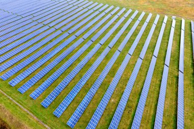 Yeşil alandaki güneş enerjisi santralinin havadan görüntüsü. Temiz ekolojik enerji üretmek için panelleri olan elektrik çiftliği.
