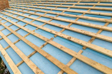 Ahşap çatı iskeleti olan tuğladan bir evin havadan görünüşü.