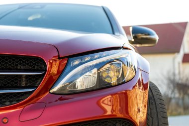 Şehrin cadde tarafında park edilmiş yeni temiz arabanın ön farının önü..