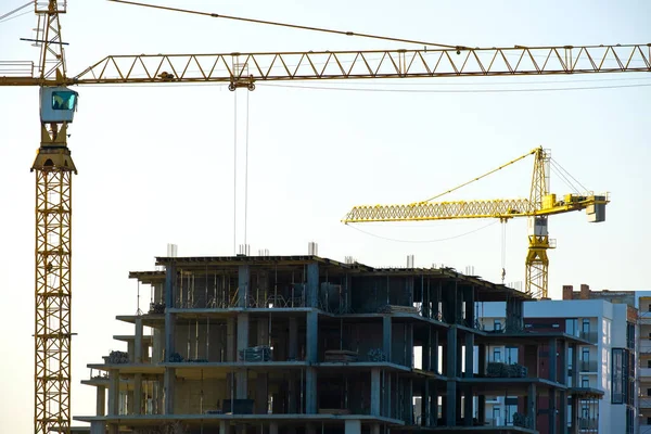 Aerial view of tower cranes and high residential apartment buildings under construction. Real estate development.