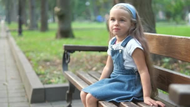 Bambina Seduta Sola Una Panchina Nel Parco Estivo — Video Stock