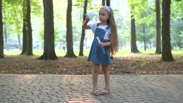 Kleines Glückliches Kindermädchen Pustet Seifenblasen Sommerpark — Stockvideo