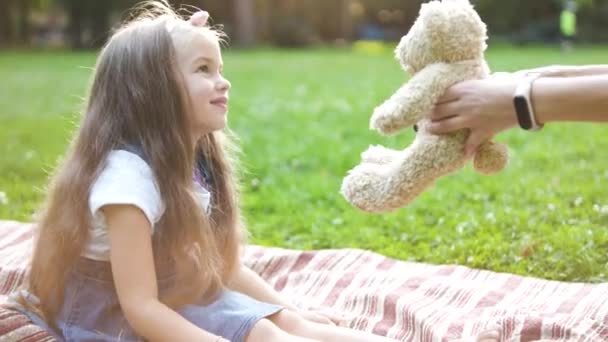 Szczęśliwe Dziecko Dziewczyna Gra Jej Pluszowy Miś Zabawka Siedzi Zielonej — Wideo stockowe
