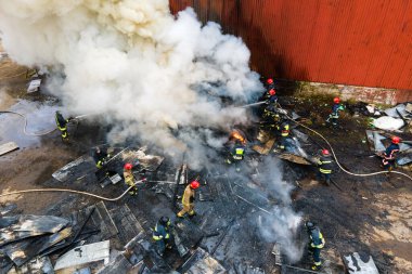 Sanayi bölgesinde eski fabrika yakınlarında ateşle savaşan itfaiyecilerin hava görüntüsü..