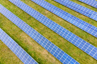 Yeşil alandaki güneş enerjisi santralinin havadan görüntüsü. Temiz ekolojik enerji üretmek için panelleri olan elektrik çiftliği.