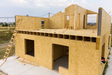 Yeni ve modern modüler evin inşaatı. İçinde köpük yalıtım malzemesi olan kompozit ahşap panellerden yapılmış duvarlar. Yeni enerji tasarruflu ev kavramı oluşturuluyor.