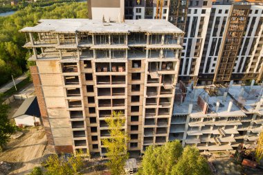 İnşaat halindeki çok katlı apartmanlar. Yüksek binaların beton ve tuğla iskeleti. Kentsel alanda gayrimenkul geliştirme.