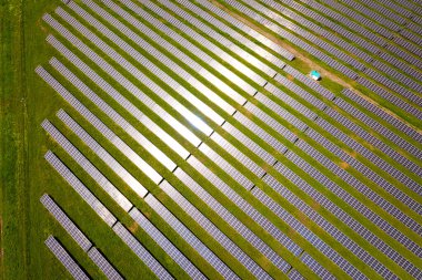 Yeşil alandaki güneş enerjisi santralinin havadan görüntüsü. Temiz ekolojik enerji üretmek için elektrik panelleri.