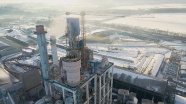 Yüksek fabrika yapısına sahip çimento fabrikasının havadan görüntüsü ve endüstriyel üretim bölgesindeki kule vinci..