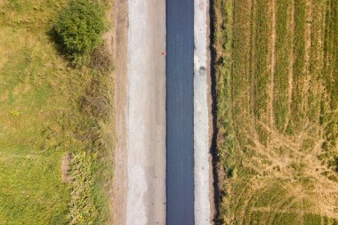 Yeni döşenmiş asfalt şeritli yeni yol yapımının havadan görünüşü.