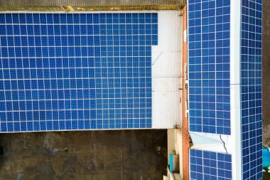 Mavi fotovoltaik güneş panelleri endüstriyel binaların çatısına temiz ekolojik elektrik üretmek için monte edildi. Yenilenebilir enerji konsepti üretimi.