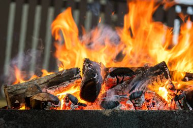 Gece, parlak yanan odunları sarı ateş alevleriyle kapatın..