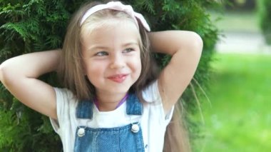 Yaz parkında mutlu bir şekilde gülümseyen güzel bir kızın portresi..