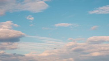 Mavi gökyüzünde hızla hareket eden bulutlarla birlikte zaman akışı.