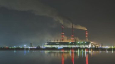 Kömür santralinin zaman aşımı. Siyah dumanlı yüksek borular. Gece atmosferi kirletiyor..