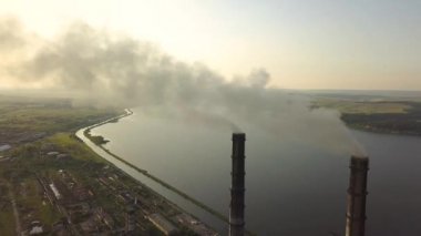 Kömür santralinden gelen gri dumanlı uzun baca borularının hava manzarası. Fosil yakıtla elektrik üretimi.
