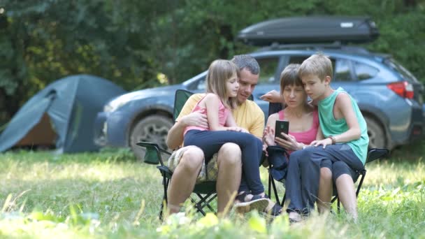 Mladí Rodiče Svými Dětmi Relaxovat Společně Kempování Stránky Procházení Smartphonu — Stock video