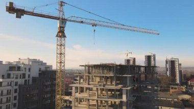 Yüksek kule vincinin ve inşaat halindeki apartmanların havadan görüntüsü. Gayrimenkul geliştirme.