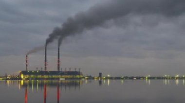 Kömür santralinin zaman aşımı. Siyah dumanlı yüksek borular. Gece atmosferi kirletiyor..