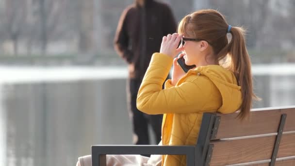 Jeune Jolie Femme Assise Sur Banc Parlant Sur Son Téléphone — Video