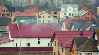 Kırsal bölgedeki özel evlerin çatılarında bacalardan yoğun duman çıkıyor..