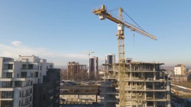 Yüksek kule vincinin ve inşaat halindeki apartmanların havadan görüntüsü. Gayrimenkul geliştirme.