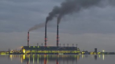 Kömür santralinin zaman aşımı. Siyah dumanlı yüksek borular. Gece atmosferi kirletiyor..