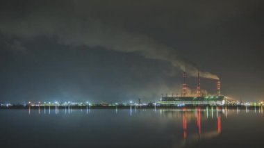 Kömür santralinin zaman aşımı. Siyah dumanlı yüksek borular. Gece atmosferi kirletiyor..