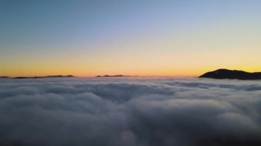 Sonbaharda yeşil ladin ormanlarıyla kaplı dağ tepelerinin üzerinde canlı gündoğumunun hava manzarası..