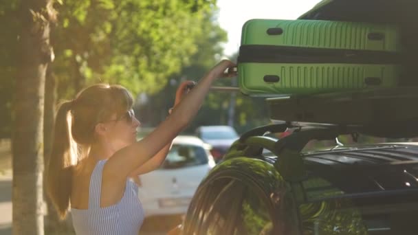 Fiatal Női Sofőr Zöld Bőröndöt Visz Városi Utcai Tetőcsomagtartóból Utazási — Stock videók