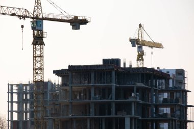 Vinçler ve inşaat halindeki yüksek konutlu binalar. Gayrimenkul geliştirme.