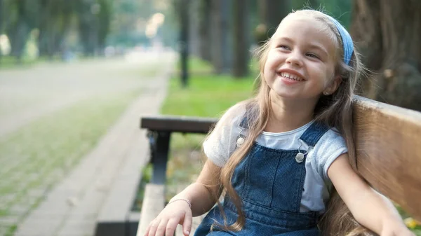 Malá Šťastná Holčička Sedí Lavičce Šťastně Usmívá Letním Parku — Stock fotografie