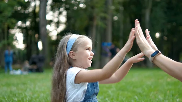 在绿色的夏季公园里 漂亮的小女孩和妈妈一起在户外打拍手 — 图库照片