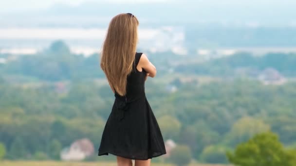 Молода Жінка Довгим Волоссям Короткій Чорній Сукні Стоїть Вершині Пагорба — стокове відео