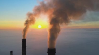 Kara dumanlı yüksek borular güneş doğarken atmosferi kirletiyor..