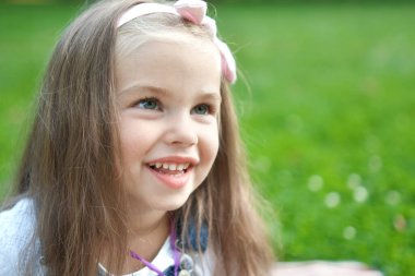 Yaz parkında mutlu bir şekilde gülümseyen güzel bir kızın portresi..