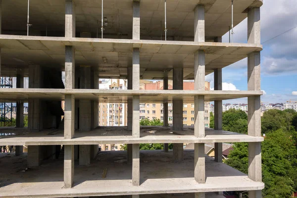 Aerial view of high frame of monolithic concrete building under construction. Real estate development.