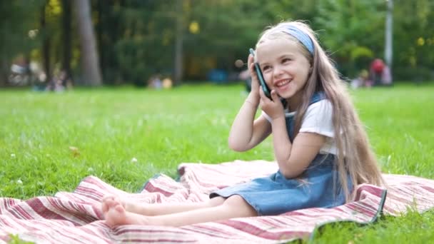 快乐的小女孩在夏日公园里用手机聊天 — 图库视频影像