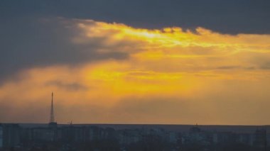 Günbatımında sarı gökyüzünde hızlı hareket eden akşam bulutlarının hızlandırılmış görüntüleri.