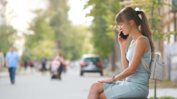 Jonge Vrouw Zitten Een Bank Praten Haar Mobiele Telefoon Buiten — Stockvideo