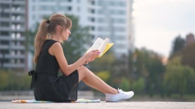 Yaz parkında kitap okuyan genç bir kadın. Eğitim ve sudy konsepti.