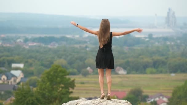 短い夏のドレスで若い幸せな女性のバックビューは喜んで丘の上に屋外で踊る — ストック動画