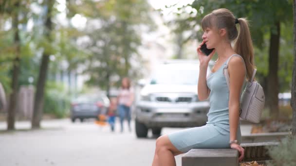Молода Зайнята Жінка Сидить Міській Вуличній Лавці Розмовляючи Мобільних Телефонах — стокове відео