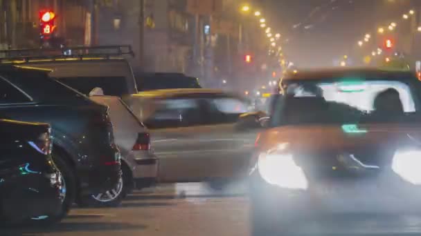 夜间将停放于路边的车辆关上 视线模糊 可看见市区街道上行驶车辆的红绿灯 — 图库视频影像