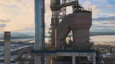 Yüksek fabrika yapısına sahip çimento fabrikasının havadan görüntüsü ve endüstriyel üretim bölgesindeki kule vinci..