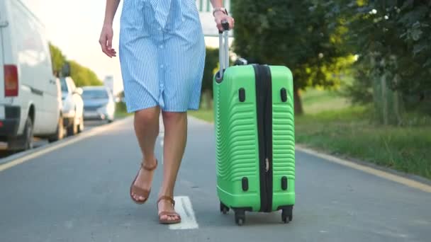 年轻女子提着绿色手提箱走在城市街道人行道上 旅行和度假概念 — 图库视频影像