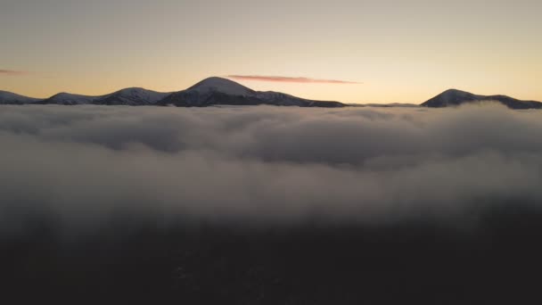 水平線に遠くの暗い山と白い高密度の雲の上の鮮やかな日の出の空中ビュー — ストック動画