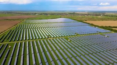 Temiz ekolojik elektrik enerjisi üretmek için birçok sıra güneş fotovoltaik paneli bulunan sürdürülebilir büyük elektrik santralinin havadan görünüşü. Sıfır emisyon kavramı ile yenilenebilir elektrik.