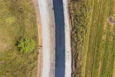 Yeni döşenmiş asfalt şeritli yeni yol yapımının havadan görünüşü.