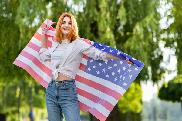 Młoda Rudowłosa Kobieta Trzymająca Flagę Usa Świeżym Powietrzu Letnim Parku — Zdjęcie stockowe